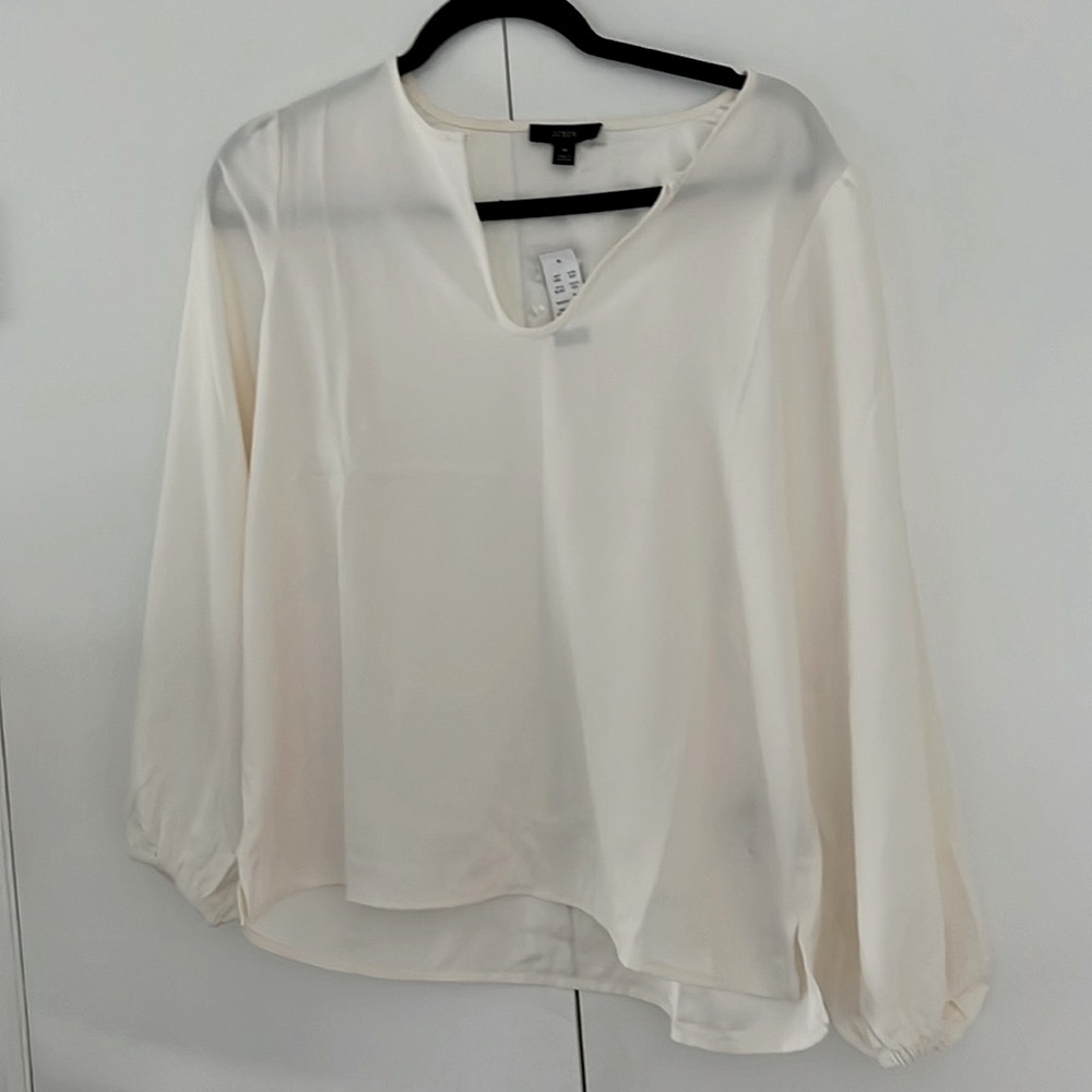 NWT J. Crew cream artist style blouse. Cinched wrists, open bottom.